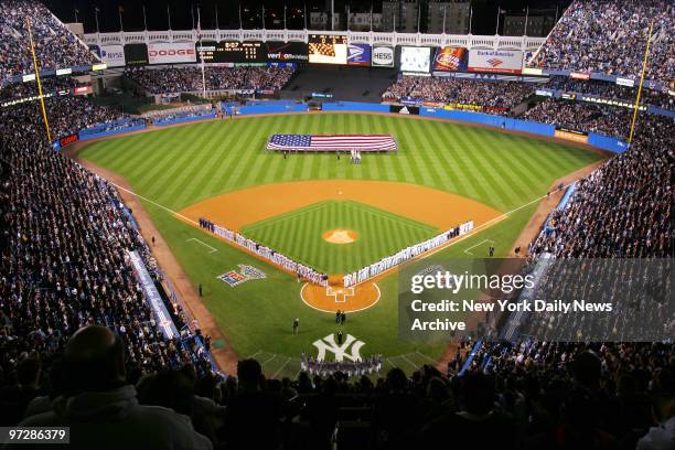 The New York Yankees and Boston Red Sox are on the field for the National Anthem before the start of the American League Championship Series at...