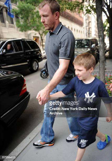 Madonna's husband Guy Ritchie with their son Rocco who is wearing a Yankee jersey, with rumors that Madonna is seeing New York Yankee Alex Rodriguez....