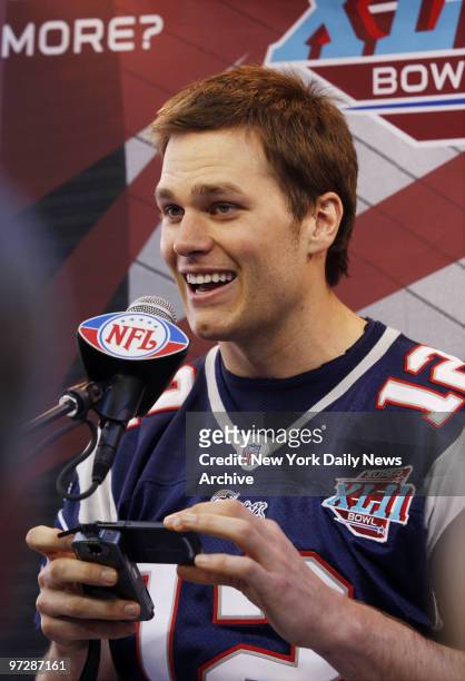 New England Patriots' Tom Brady snaps a photo on his cell phone while at the microphone during Media Day at the University of Phoenix Stadium,...