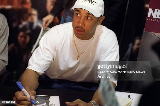 Former New York Knicks' basketball player John Starks signs autographs for fans at his Three Point Wireless communications store on Eighth Ave.