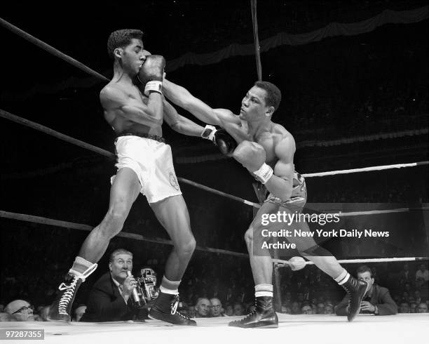 Daily News 160-lb open champion Jose Torres fires a right to the head of Chicago's Wilbur McClure in 1958 Inter-city championship at the Garden....