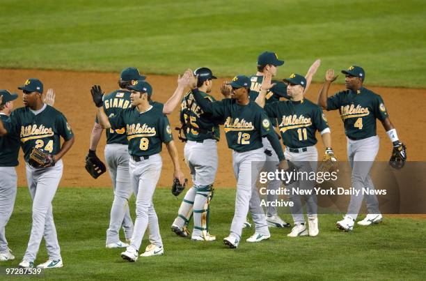 The Oakland Athletics celebrate with high fives after topping the New York Yankees, 5-3, in Game 1 of the American League Division Series at Yankee...