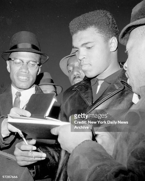 Malcolm X joins the group seeking autographs from Cassius Marcellus Clay .