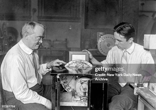 Francis Jenkins and his assistant James Roberts with machine on which he received movies by radio that were transmitted from the Anacostia Laboratory...