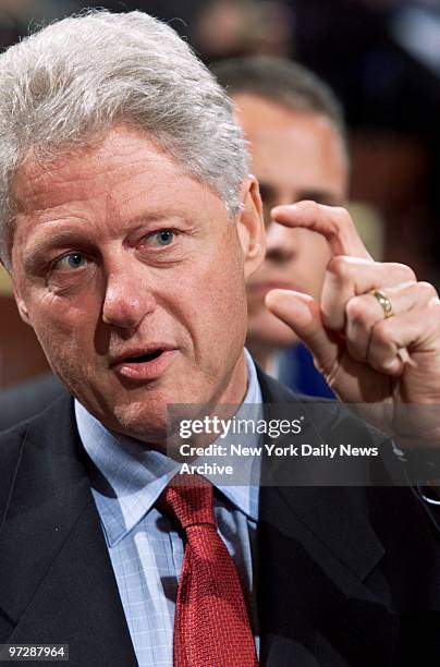 Former President Bill Clinton talks with a friend during halftime of game between the New York Liberty and the Detroit Shock at Madison Square...