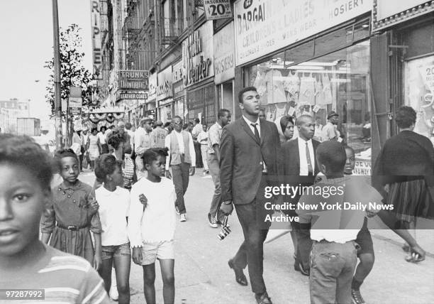 The Pied Piper of Harlem, Cassius Clay, whistling a sweet tune as he nonchalantly strolls down a street in Harlem.
