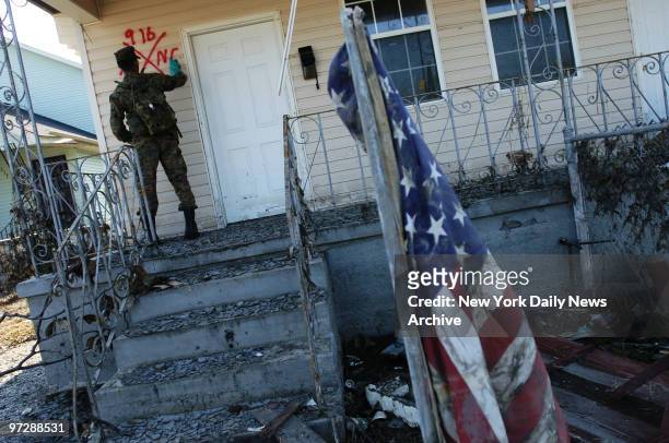 Marine from Camp Lejeune, N.C., marks a home to indicate he found no occupants as houses in the lower Ninth Ward are checked for bodies or people who...