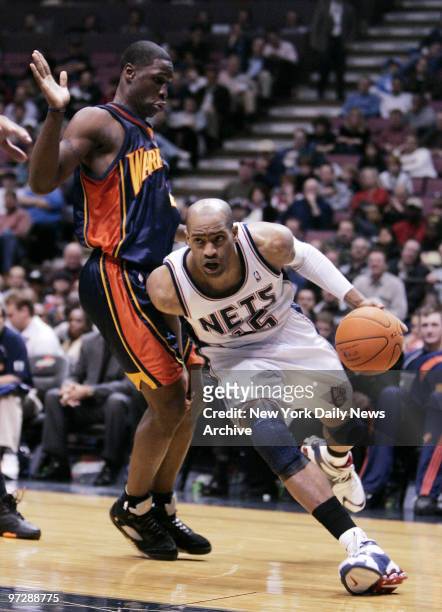New Jersey Nets' Vince Carter dribbles the ball past Golden State Warriors' Mickael Pietrus during the fourth quarter of a game at Continental...