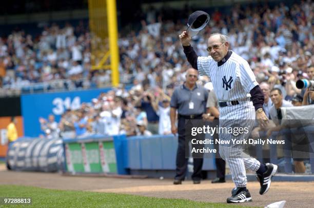 Former New York Yankees' catcher and manager Yogi Berra - a baseball Hall of Famer - tips his cap as he's introduced during 59th annual Old-Timers'...