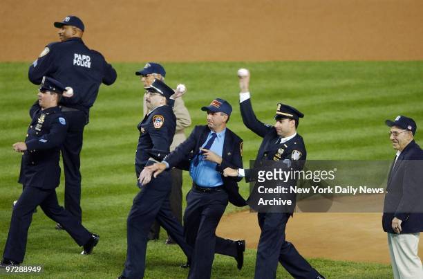 Members of the Police and Fire Departments throw out the first pitches at a pregame ceremony in Yankee Stadium honoring the victims of the Sept. 11...