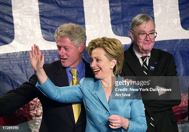 Senator-elect Hillary Rodham Clinton, flanked by husband President Bill Clinton and outgoing Sen. Daniel Patrick Moynihan, waves to the crowd after...