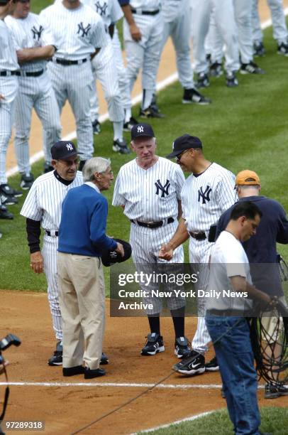 Former New York Yankees' shortstop Phil Rizzuto talks with former Yanks' catcher and manager Yogi Berra, pitcher Whitey Ford and outfielder Reggie...