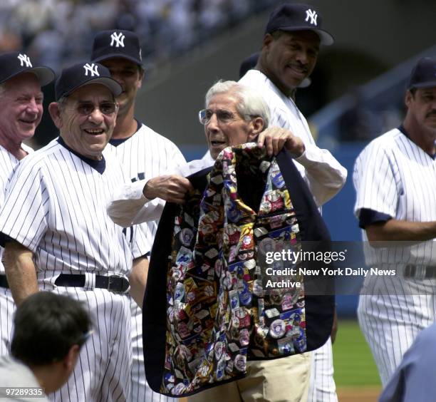 Former New York Yankees' shortstop Phil Rizzuto shows off the baseball-themed lining of his jacket while he's introduced as former Yankees' catcher...