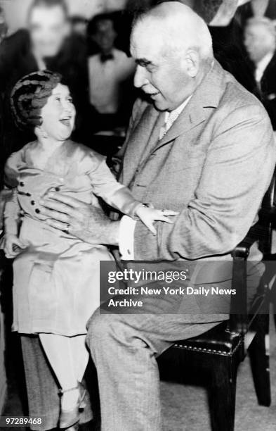 Senatorial dignity was outraged when tiny Lya Graf, 21-inch circus midget posed for cameramen on lap of J.P. Morgan, giant of finance, just before...