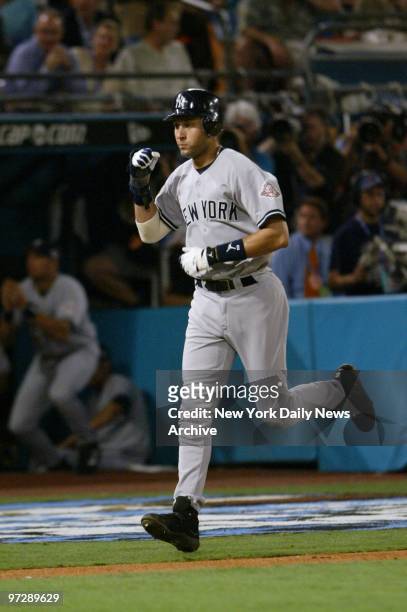 New York Yankees' Derek Jeter clenches his fist as he heads home after a bases-loaded walk in the fourth inning of Game 3 of the World Series against...