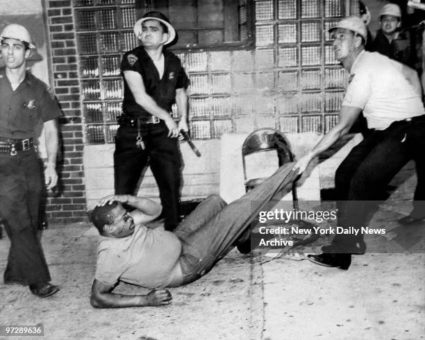 Man resisting arrest is taken from area near where police officer Frederick Toto was fatally shot during riot.