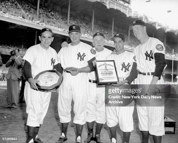 Manager Casey Stengel gets together with some award-winning members of his World Champion New York Yankees during pre-game ceremonies at the Stadium....