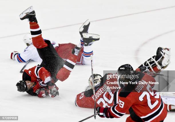 New Jersey Devils' Paul Martin, left, and New York Rangers' Sean Avery land after a collision with Devils' goaltender Martin Brodeur in the 3rd...