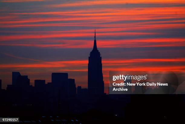 Manhattan skyline is dark as the sun comes up on the morning after a massive power failure caused the largest power outage in the nation's history,...