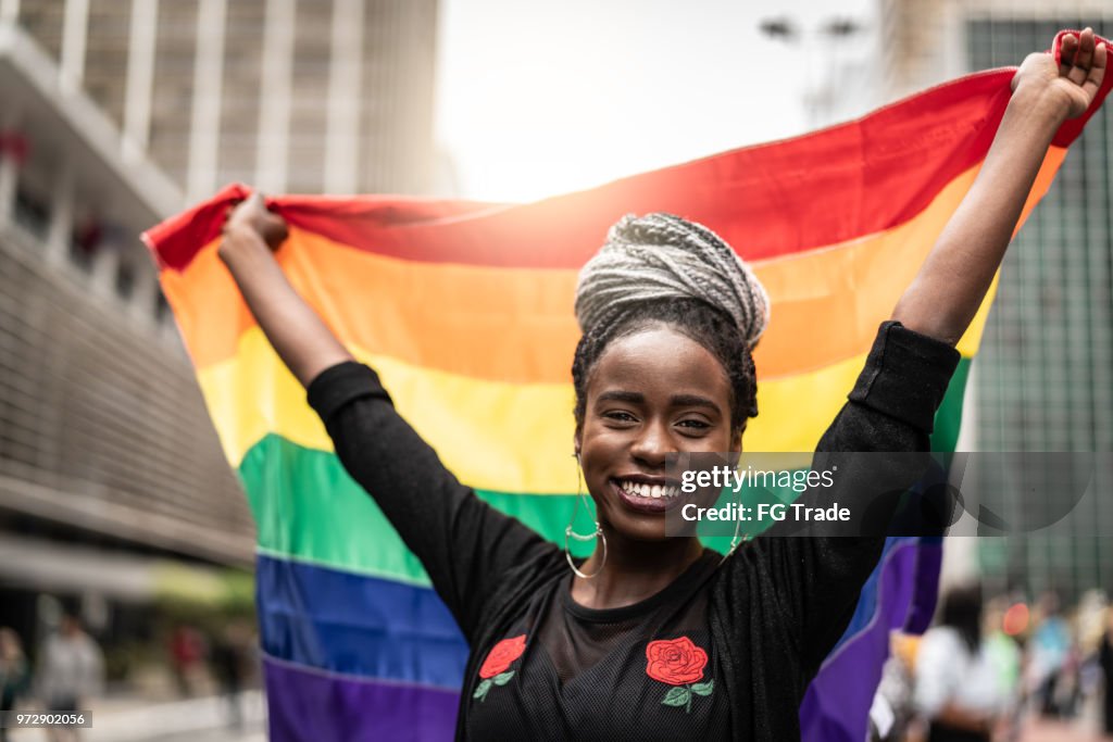 Kvinnan vinkar Regnbågsflaggan på Gay Parade