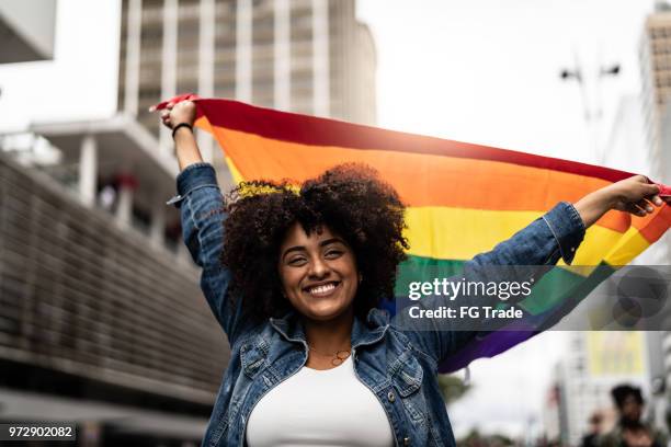 mulher acenando a bandeira do arco-íris na parada gay - direitos dos gays - fotografias e filmes do acervo