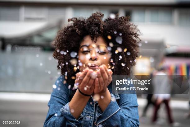 portrait of cute woman blowing confetti - gratidão imagens e fotografias de stock