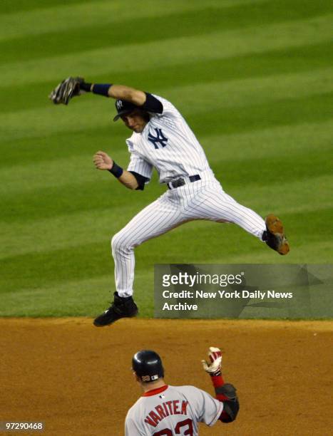 New York Yankees' Derek Jeter leaps but can't get to the ball overthrown by teammate Karim Garcia on hit by Boston Red Sox' Jason Varitek in second...