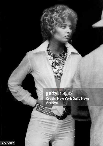 Caption for photo from Daily News read "This gal is with it in tight pants, plunging halter and spangles" she attends a Rolling Stones concert at...