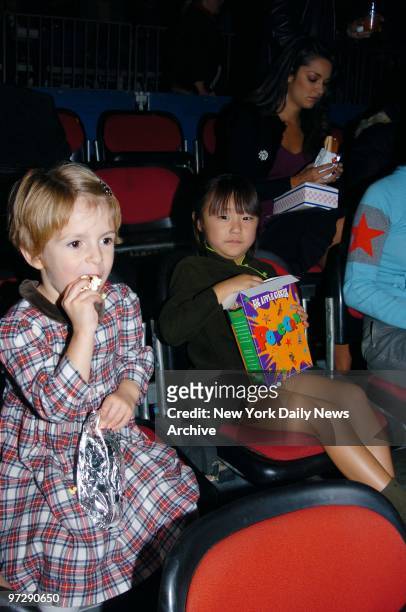 Manzie Tio and Bechet Dumaine, the daughters of Woody and Soon-Yi Allen, munch on popcorn during the Big Apple Circus' opening night gala benefit in...