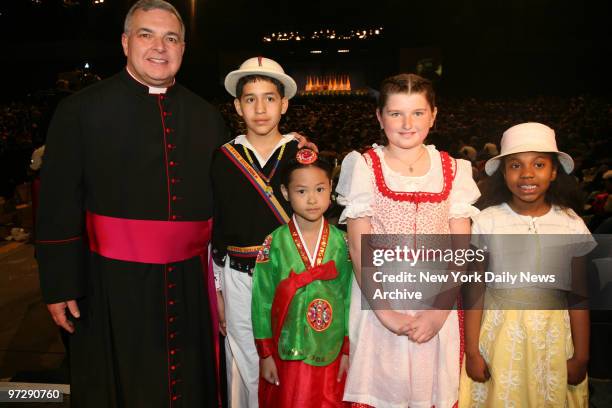 Cardinal with Eric Flores Casey Kim Grace Weiderhold Yael Barber presented bouquet of flowers and a replica of the Immaculate Conception stained...