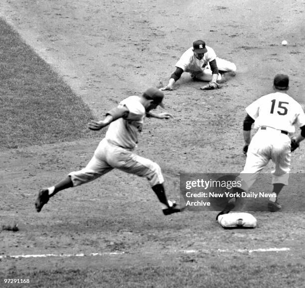 Carl Furillo takes final stride to first in seventh after bouncing single off Whitey Ford's glove. Billy Martin sits on ground after falling while...