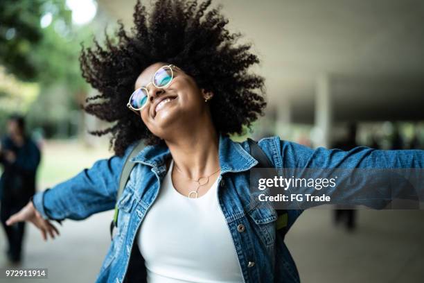 portrait de femme souriant avec fond coloré - les bras écartés photos et images de collection