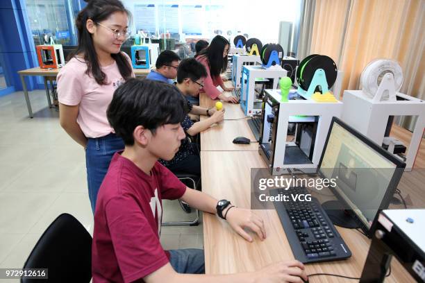 Professors and students print replicas the FIFA World Cup Trophy at the 3D-printing research center in the Nantong Institute of Technology on June...