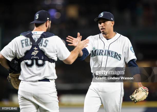 Edwin Diaz of the Seattle Mariners greets David Freitas after earning the save against the Los Angeles Angels of Anaheim at Safeco Field on June 12,...