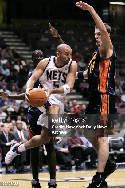 New Jersey Nets' Jason Kidd goes airborne up against Golden State Warriors' Andris Biedrins during the first quarter of a game at Continental...