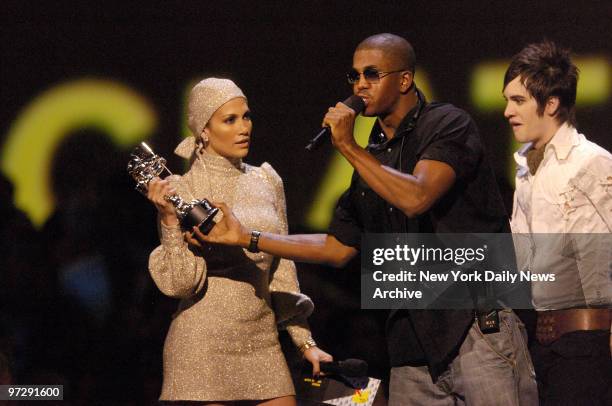 Jennifer Lopez keeps a grip on the award being presented to Panic! At the Disco as an intruder tries to grab it during the 2006 MTV Video Music...