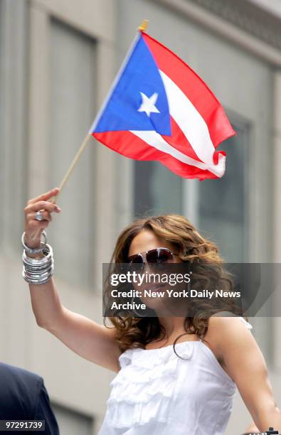 Jennifer Lopez shows her pride as she waves a flag while riding a float up Fifth Ave. During the 50th annual Puerto Rican Day Parade.