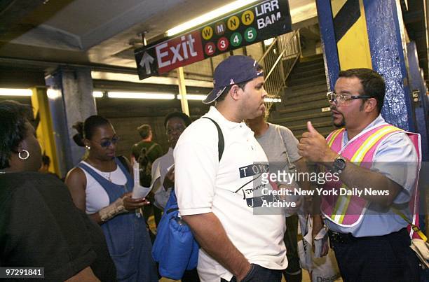 Transit worker Francisco Aybar gives directions to a straphanger at the Dekalb Ave., Brooklyn, station on the first workday morning of major subway...