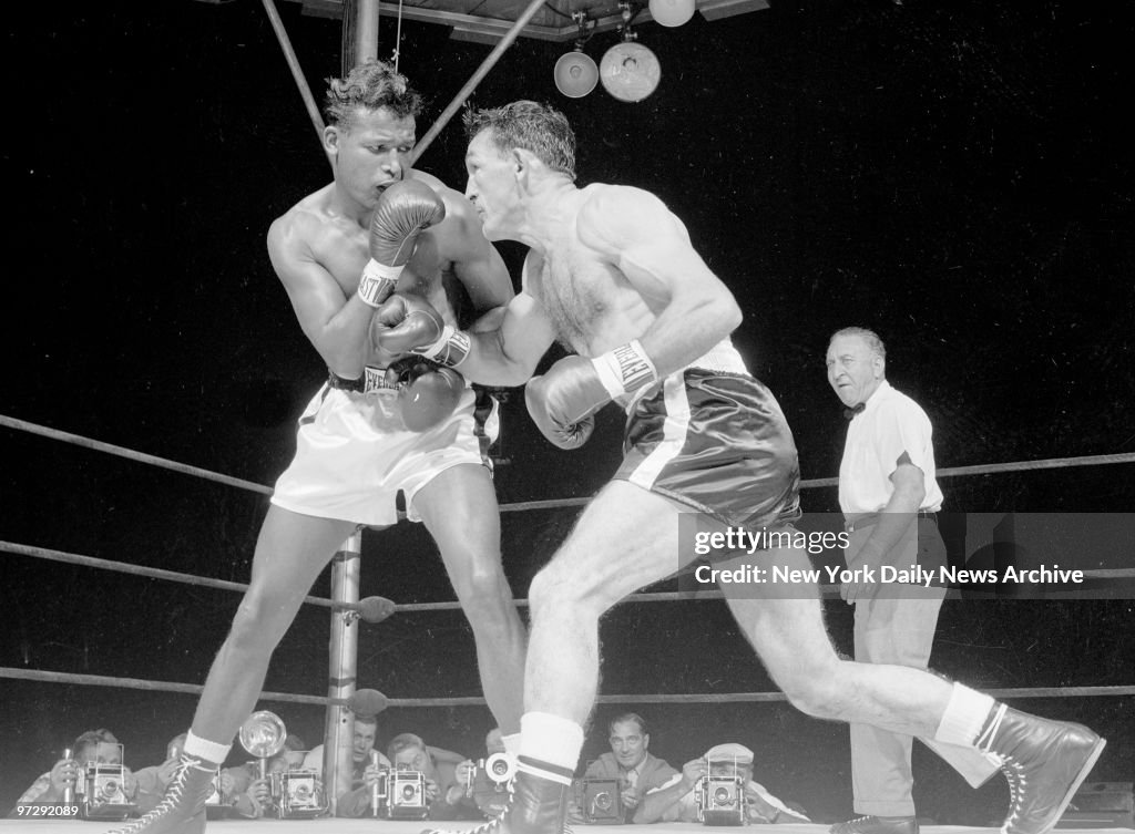 Carmen Basilio (right) rips right hand at Ray Robinson in fi