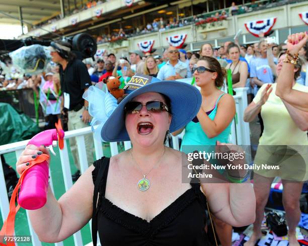 Jennifer Starr of Wilkes-Barre, PA, uses a battery-powered fan with spritzer to stay cool while rooting on an earlier race at the running of the...