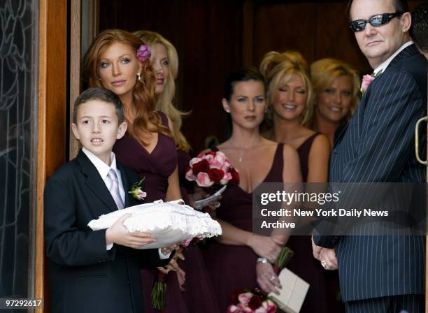 The ring bearer, bridesmaids and Dalton Rickter, the father of the bride, wait for bride Alicia Rickter to arrive at St. Jude's Catholic Church in...