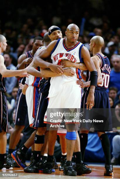 New Jersey Nets' Kenyon Martin holds back New York Knicks' Vin Baker after a shoving match between Nets' Richard Jefferson and Knicks' Frank Williams...