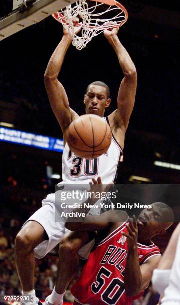 New Jersey Nets' Kerry Kittles dunks for two points as Chicago Bulls' Greg Anthony ducks out of the way during game at Continental Airlines Arena....