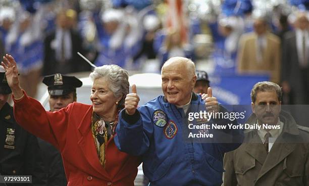 John Glenn and wife Annie greet crowd from open car in parade up lower Broadway honoring Glenn and crew of the Discovery space shuttle.