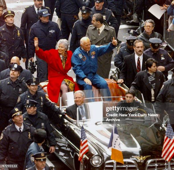 John Glenn and wife Annie greet crowd from open car in parade up lower Broadway honoring Glenn and crew of the Discovery space shuttle.