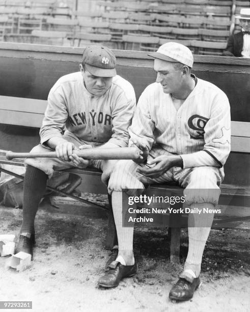 Shoeless Joe Jackson of the Chicago White Sox and the New York Yankees' Babe Ruth look at one of Babe's home run bats.