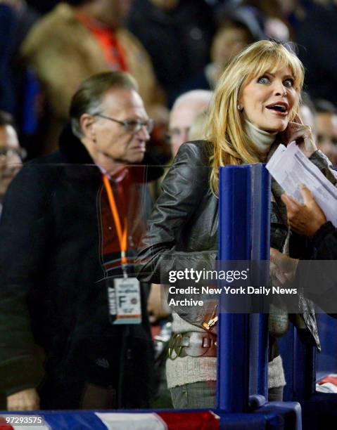 Shawn King, accompanied by husband Larry King, stands by the field at Shea Stadium after singing the national anthem at the start of Game 2 of the...