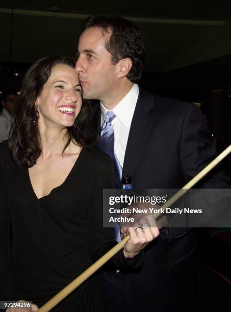 Jerry Seinfeld gives wife Jessica a kiss for good luck as she plays pool at the Amsterdam Billiards Club where they held a party to raise money for...