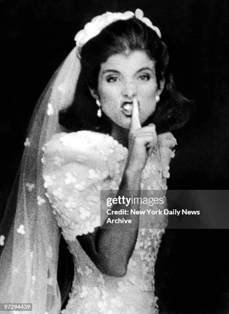 Caroline Kennedy, in a white organza silk Caroline Herrera gown decorated with shamrocks, signals photographers to shush as she enters Our Lady of...