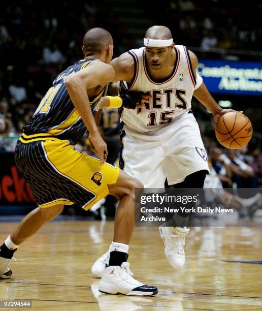 New Jersey Nets' Vince Carter , who was recently acquired from the Toronto Raptors, is guarded by the Indiana Pacers' Reggie Miller during his home...